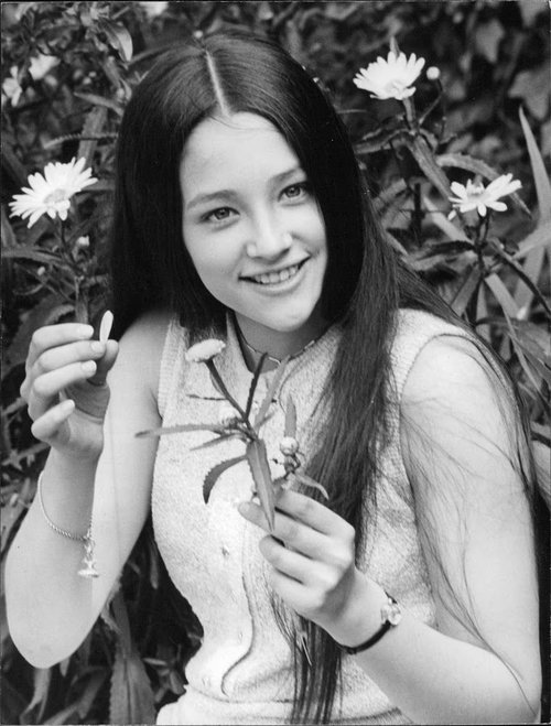 olivia-hussey-holding-a-flower-stem-and-smiling-emilio-lar.jpg